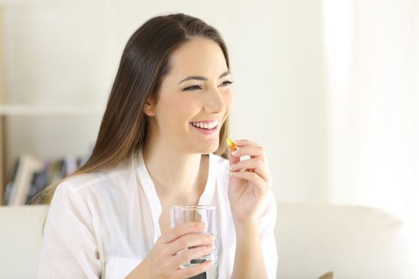 Happy woman with Nutrient Deficiency taking vitamin